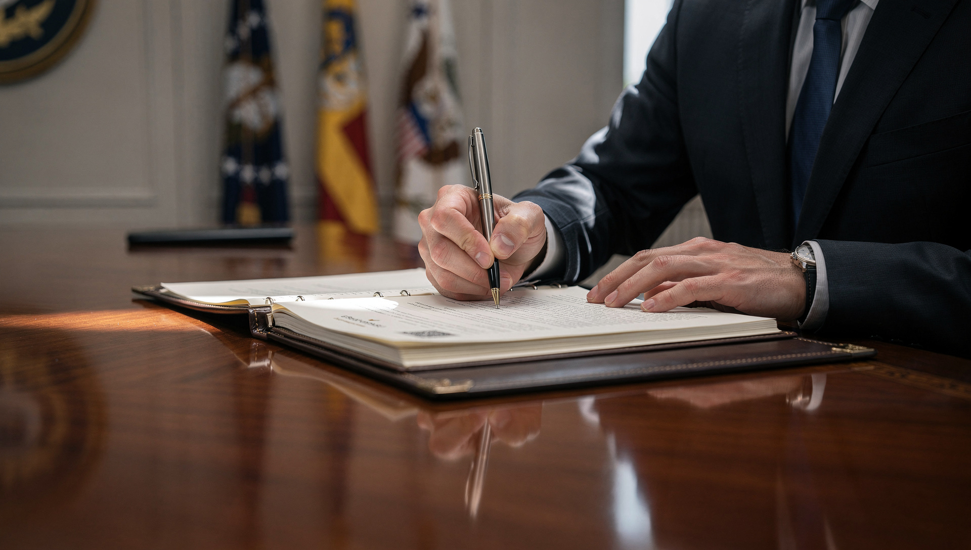 government official signing official documents at a formal institutional desk